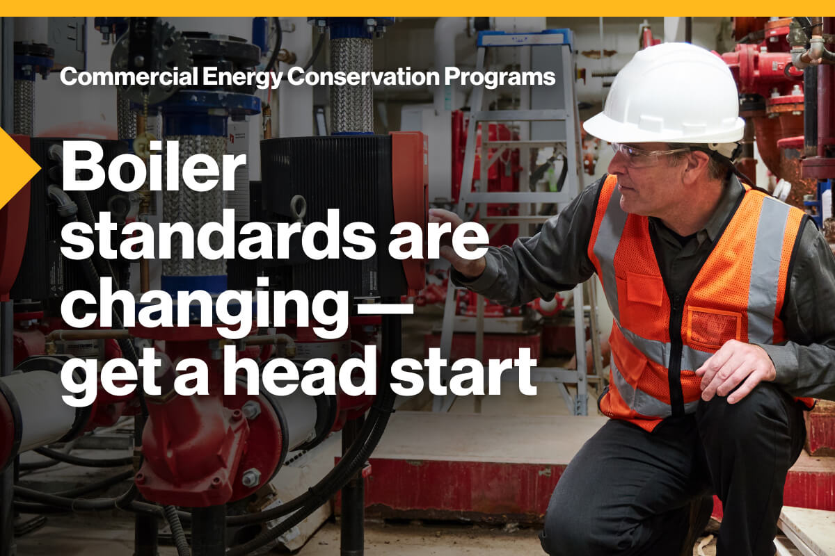 Commercial Energy Conservation Programs: Boiler standards are changing—get a head start. An image of a worker wearing a hardhat and safety vest, kneeling, while operating a boiler.