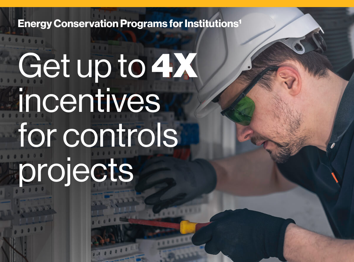 Energy Conservation Programs for Institutions¹ Get up to 4X incentives for controls projects: Image of a technician in safety gear and reflective glasses working on an electrical control panel.