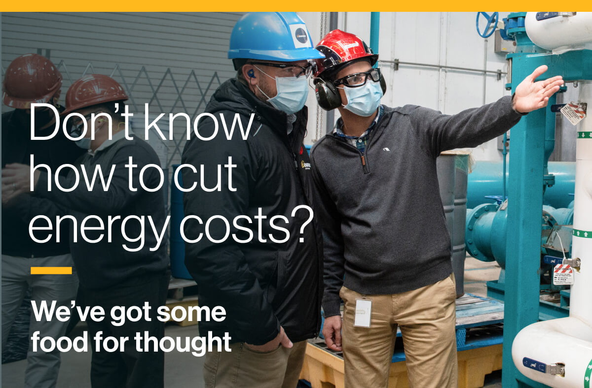 Don’t know how to cut energy costs? We’ve got some food for thought: An image of two workers wearing hard-hats, goggles and surgical masks while examining gas pipes.