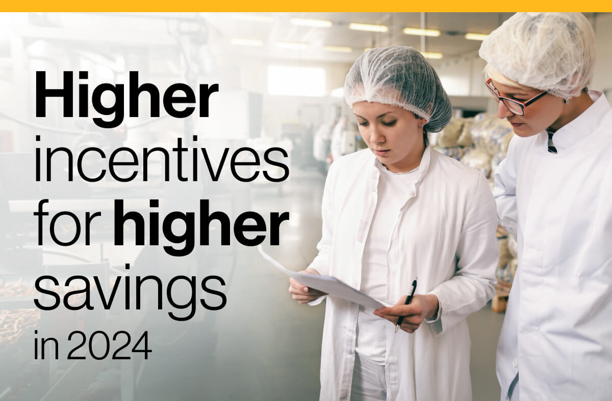 Higher incentives for higher savings in 2024: Image of two cooks in an industrial kitchen, wearing hair nets. One cook examines documents while the other watches.