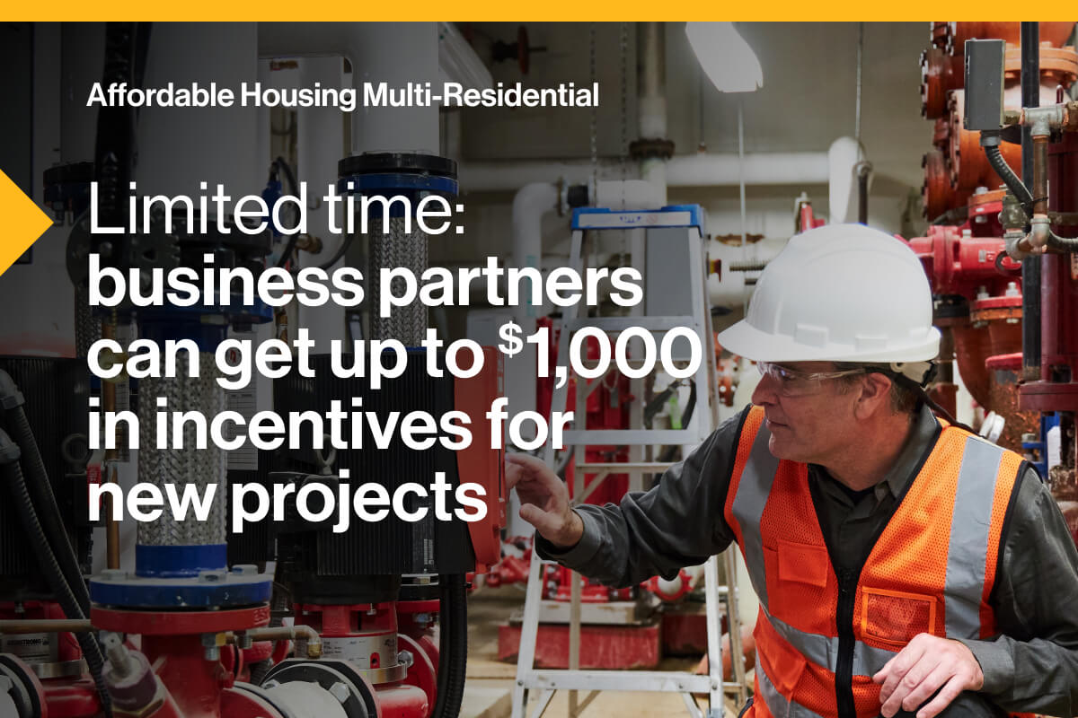 Affordable Housing Multi-Residential. Limited time: business partners can get up to $1,000 in incentives for new projects. An image of a worker wearing a hardhat and safety vest, kneeling, while operating a boiler.
