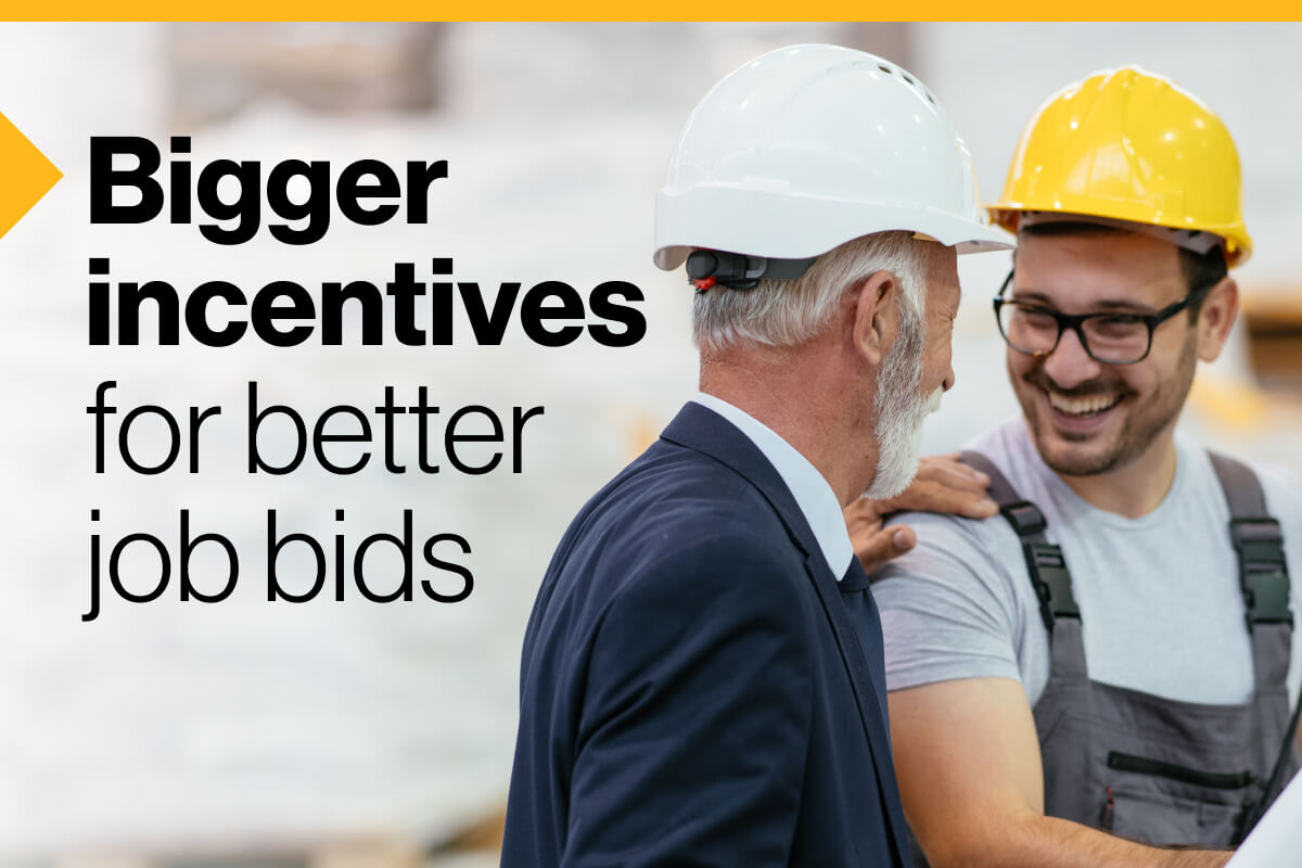 Bigger incentives for better job bids: An image of two people wearing hard hats, one in a suit and the other in overalls, smiling and laughing.
