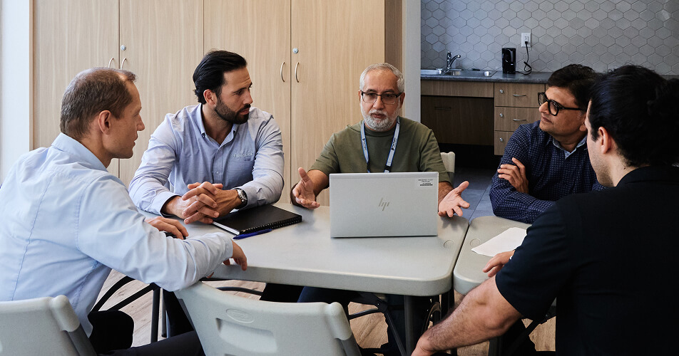 A group of people having a discussion in an office meeting room.